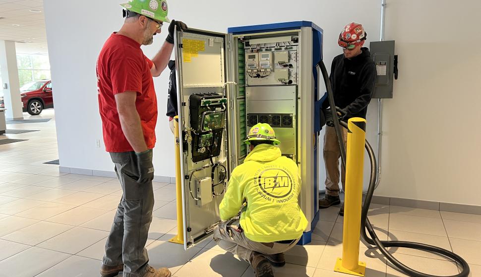 Multiple electricians inspect newly installed interior Level 3 DC Fast Charging EV Charger