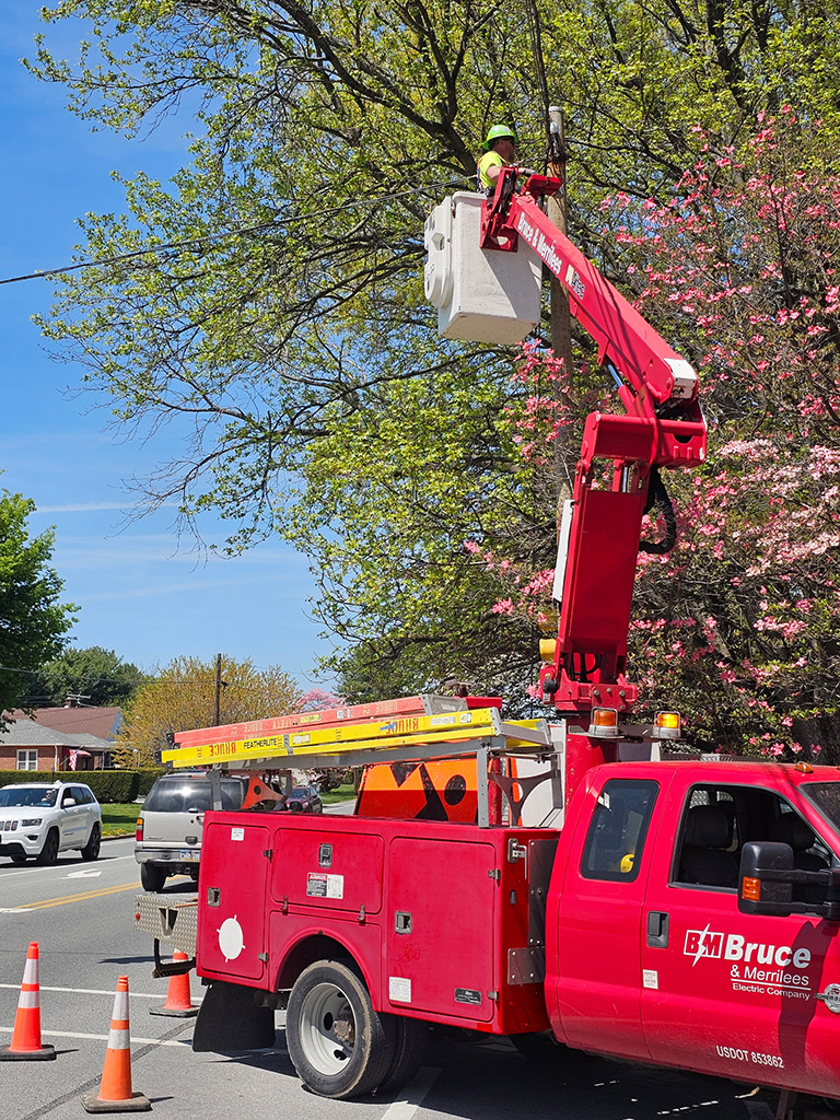 Bruce & Merrilees union electrician in bucket truck installing traffic signal upgrades