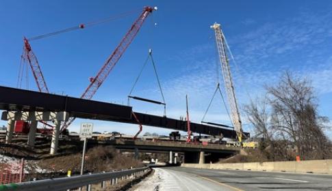 Three construction cranes are used to lift 295-foot long steel girders into place along I-495 in Northern Virginia