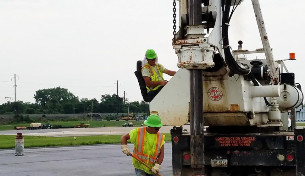 One man supervises drilling for installation of new runway lights
