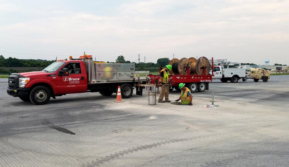 Electricians pre-assemble runway lights (wide shot)