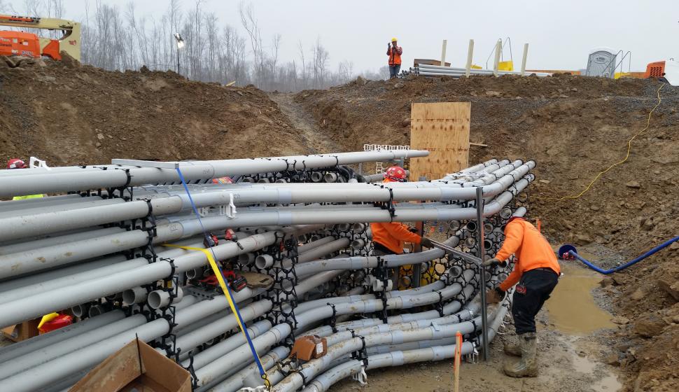 An electrician adjusts a network of electrical conduit and supports