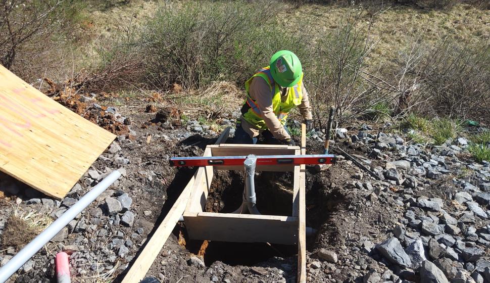 Construction worker builds highway lighting concrete form