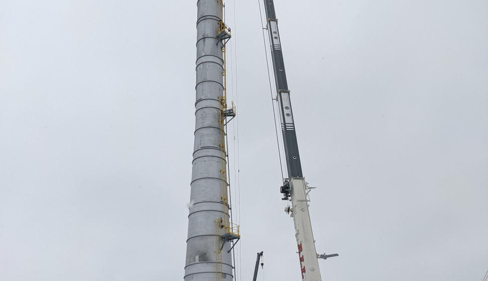 Crane lifts man basket to top of 250-foot smokestack for steel furnace