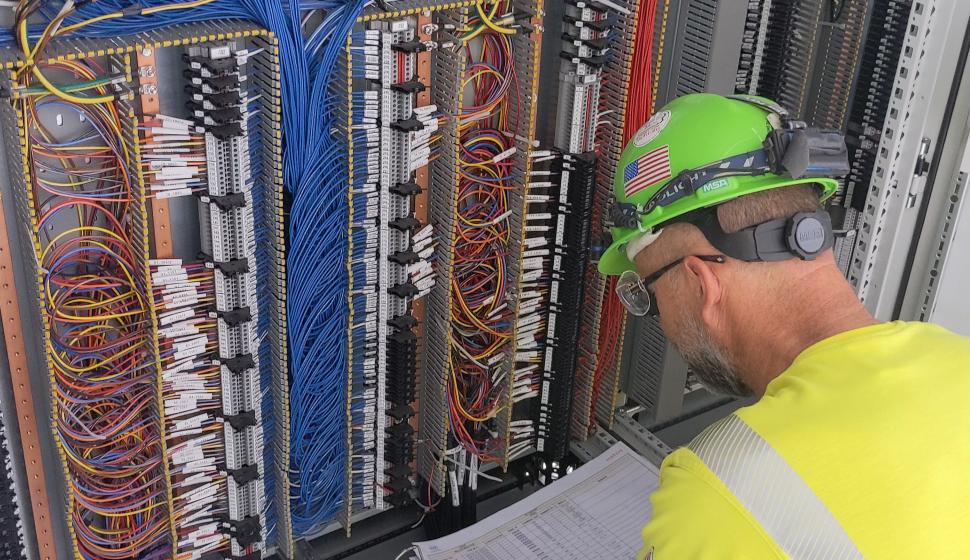Electrician compares schematics with 1,000 terminations inside furnace I-O relay cabinet