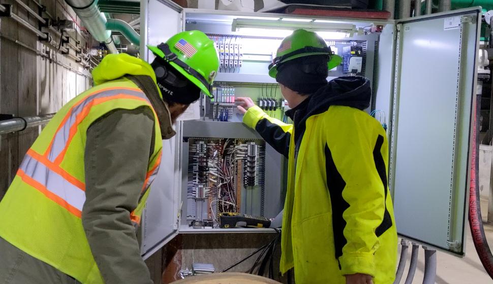 Foreman and electrician verify location of terminations in I-O relay cabinet